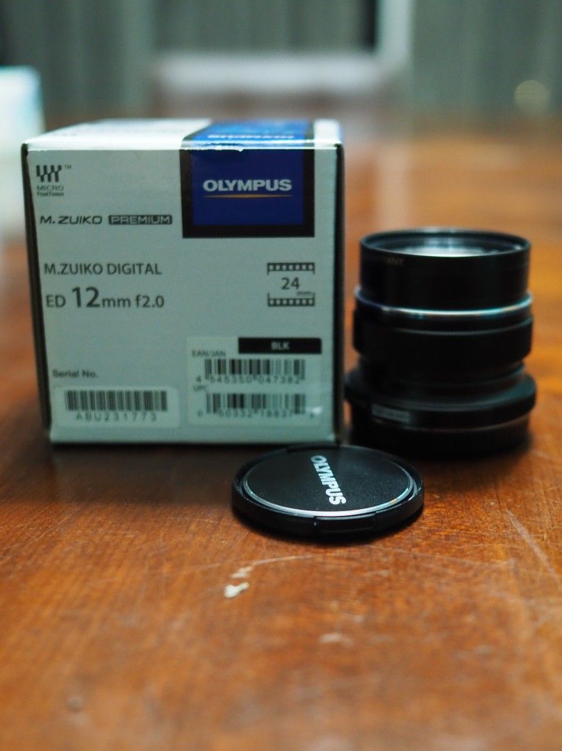 Olympus M.Zuiko 12mm f2.0 with B+W UV Filter (Category: Lens & Kits) located in Singapore. Submitted by ariprahasto (Listing ID 1377700436, Image 1). Description: full set including retail packaging. black colour. inclusive of 46mm B+W UV filter. Stored in dry cabi.