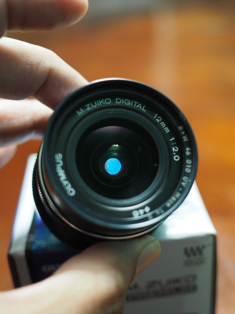 Olympus M.Zuiko 12mm f2.0 with B+W UV Filter (Category: Lens & Kits) located in Singapore. Submitted by ariprahasto (Listing ID 1377700436, Image 3). Description: full set including retail packaging. black colour. inclusive of 46mm B+W UV filter. Stored in dry cabi.