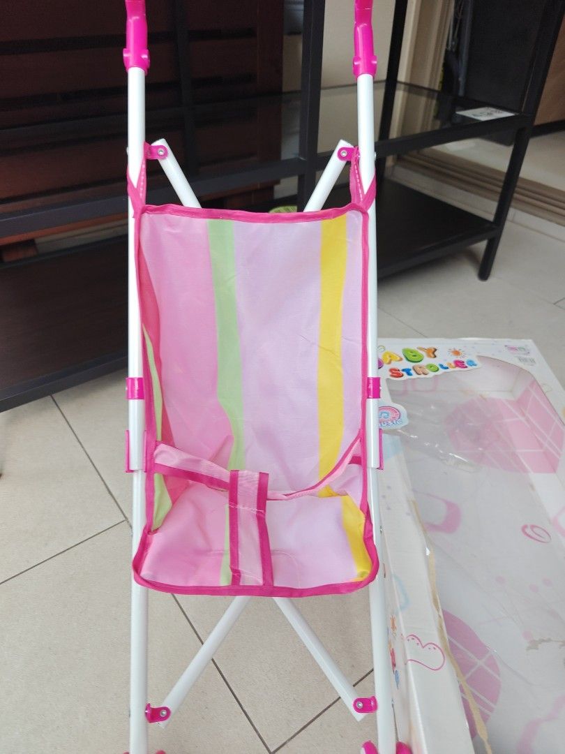 Baby's Happy Hour Toy Stroller. Pre love. Selling at $9 (Category: Strollers) located in Singapore. Submitted by Bien.loh.7 (Listing ID 1377826628, Image 2). Description: - Adorable pink and white toy stroller. - Features a handy storage pouch. - Includes original box (shows wear). - Ideal for imaginative play and doll adventures..