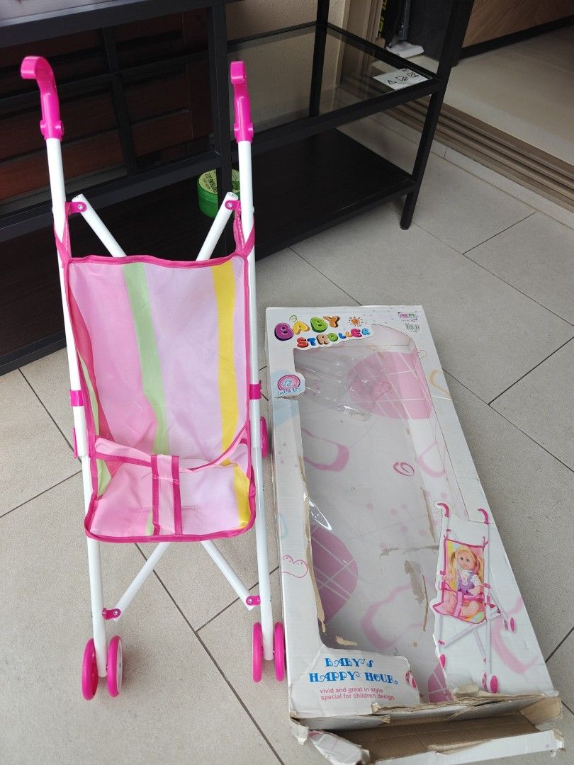 Baby's Happy Hour Toy Stroller. Pre love. Selling at $9 (Category: Strollers) located in Singapore. Submitted by Bien.loh.7 (Listing ID 1377826628, Image 1). Description: - Adorable pink and white toy stroller. - Features a handy storage pouch. - Includes original box (shows wear). - Ideal for imaginative play and doll adventures..