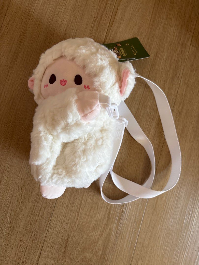 Cute Sheep Plushie Crossbody Bag (Category: Cross-body Bags) located in Singapore. Submitted by our.little.angels (Listing ID 1377826956, Image 1). Description: Adorable sheep plushie crossbody bag. Features a fluffy white exterior, pink accents, and a convenient adjustable strap. Perfect for carrying small essentials. Brand new with tag. Self collect Sembawang.