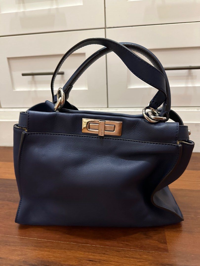 Fendi Peekaboo Handbag - Navy Blue (Category: Bags & Wallets) located in Singapore. Submitted by red_devil24 (Listing ID 1377944130, Image 1). Description: Authentic Fendi Peekaboo handbag in navy blue. Features a top handle and a detachable shoulder strap for versatile carrying options. The bag has a secure turn-lock closure and silver-tone hardware. In excellent condition, ready to be your next statement piece..