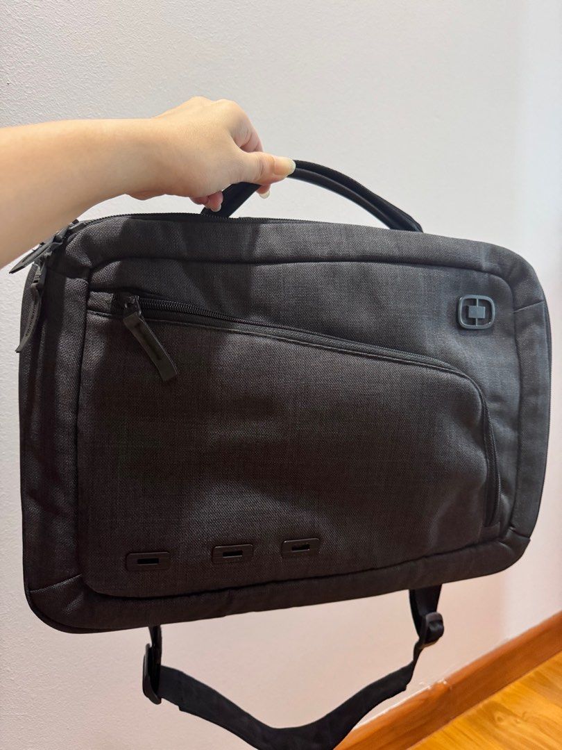 OGIO Laptop Briefcase - Grey (Category: Briefcases) located in Singapore. Submitted by the.restless (Listing ID 1377768477, Image 1). Description: This OGIO laptop briefcase is in great condition. It features multiple compartments for storage, including a front pocket and a main compartment. It has a handle and a shoulder strap for carrying. The bag is made of a durable material and is perfect for work or travel..