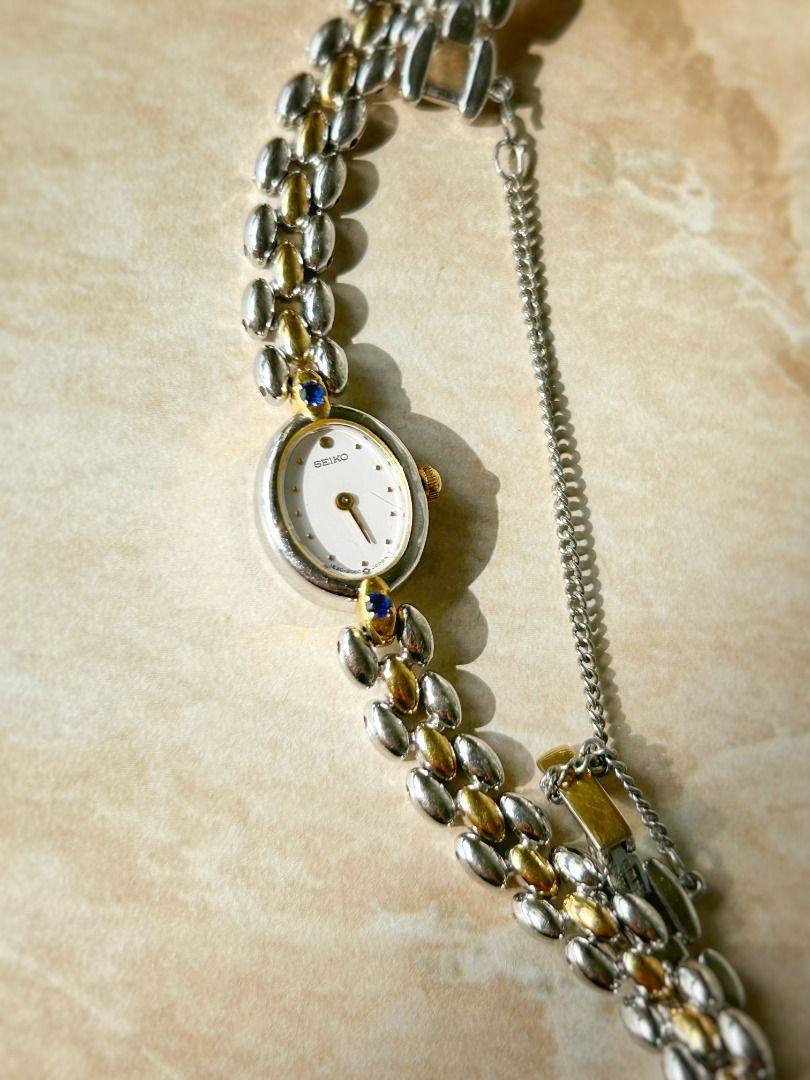 SEIKO Vintage Ladies Watch Petite Oval White Dial with Twin Blue Sapphires Two-Tone Bracelet (Category: Women's Watches) located in Singapore. Submitted by ourvintage.era (Listing ID 1377770296, Image 1). Description: Petite, elliptical and dainty dial accented by two tiny sapphires, in a slim two-tone bracelet. A well-loved piece by many of our collectors. (Follow our IG page @ourvintage.era for more videos & images of this timepiece) Fair condi