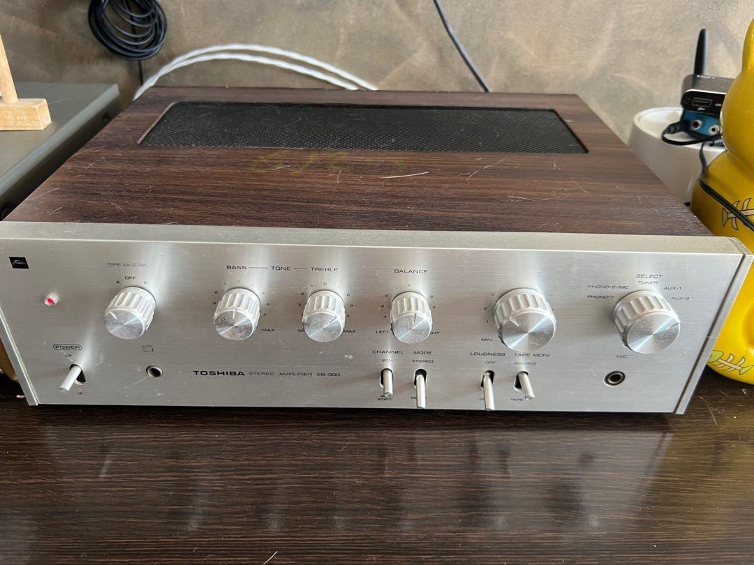 Toshiba Stereo Amplifier SB-300 (Category: Soundbars, Speakers & Amplifiers) located in Singapore. Submitted by yokelimyap (Listing ID 1377771981, Image 1). Description: Vintage Toshiba SB-300 stereo amplifier. Features controls for speakers, bass, tone, treble, balance, loudness, and tape monitor. Includes phono and aux inputs. Silver faceplate with wood grain top. A classic piece for any audio enthusiast. Left channel has a bit of noise but I b