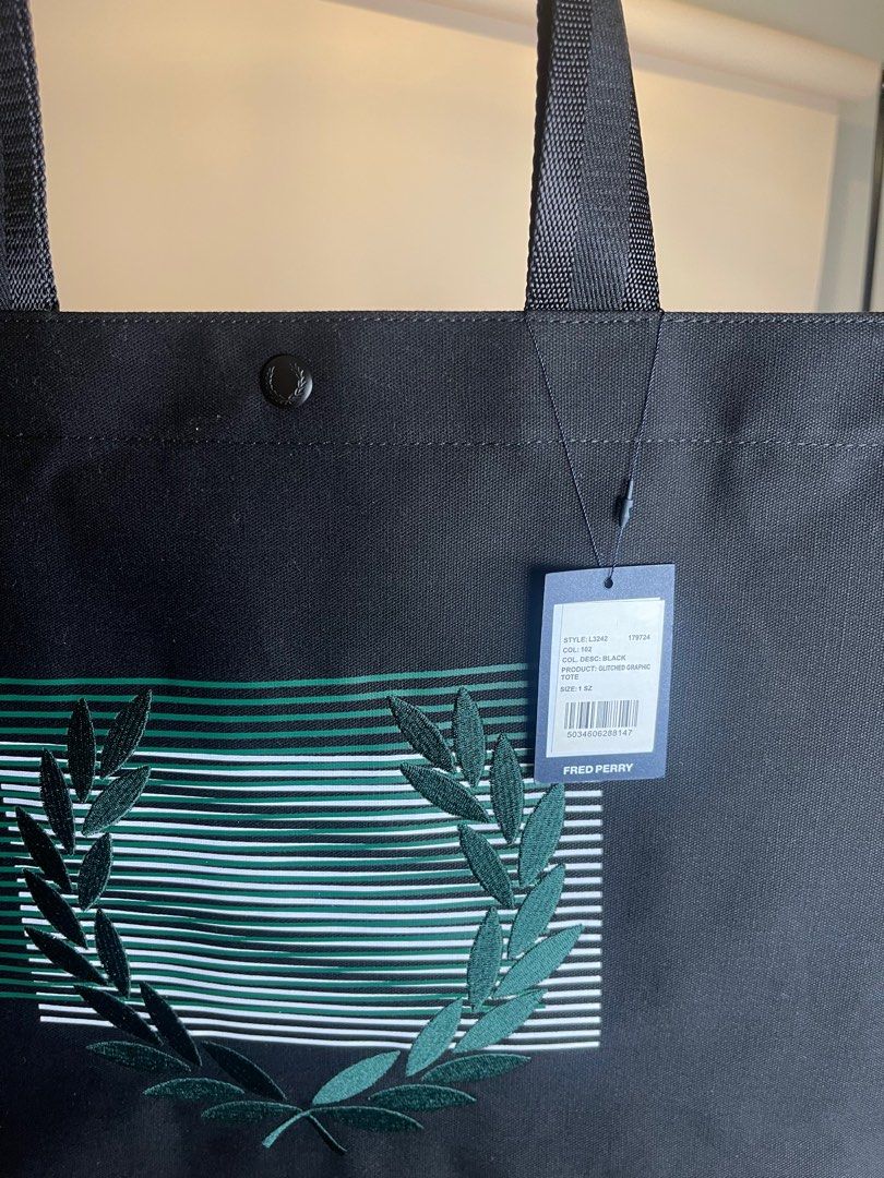 Authentic & Brand New Fred Perry Glitched Graphic Tote (Category: Luxury Apparel) located in Antipolo. Submitted by curatedlabelsph (Listing ID 1372965483, Image 3). Description: Authentic & Brand nNew Glitched Graphic Tote Bag Model: L3242 Color: Black Size: L:35.5cm H:35cm W: 13cm Code: L3242-102 Description: Cotton Canvas/ Glitch Laurel Wreath/ Durable Webbing Straps/ Branded Press Stud Fastening/ Printed lining with internal zip pocket Instag
