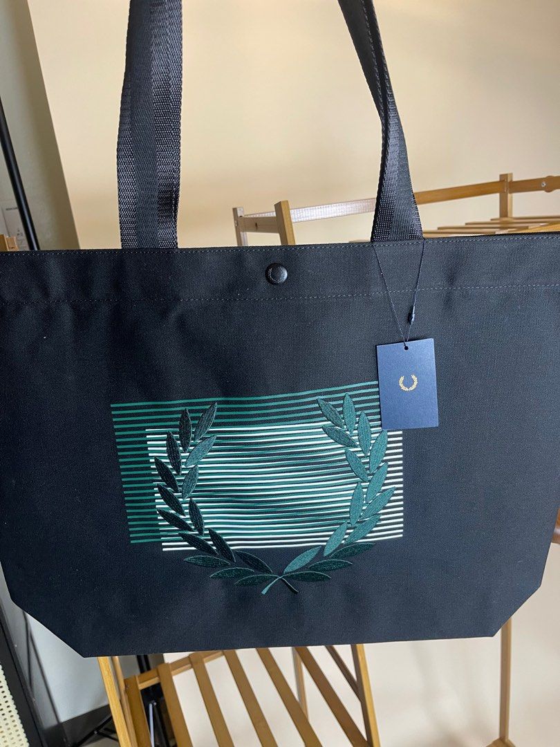 Authentic & Brand New Fred Perry Glitched Graphic Tote (Category: Luxury Apparel) located in Antipolo. Submitted by curatedlabelsph (Listing ID 1372965483, Image 2). Description: Authentic & Brand nNew Glitched Graphic Tote Bag Model: L3242 Color: Black Size: L:35.5cm H:35cm W: 13cm Code: L3242-102 Description: Cotton Canvas/ Glitch Laurel Wreath/ Durable Webbing Straps/ Branded Press Stud Fastening/ Printed lining with internal zip pocket Instag