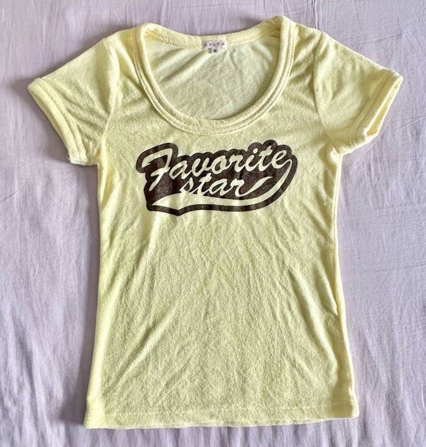 y2k light yellow tee (Category: Shirts) located in Singapore. Submitted by chrms (Listing ID 1372938986, Image 1). Description: ptp 38cm, length 58cm - tagged size M, fits S-M - thrifted vintage jpn brand tracked mailing only: $3.50.