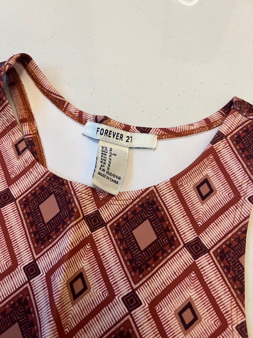 Patterned Top (Category: Sleeveless) located in Johor Bahru. Submitted by amberr257 (Listing ID 1373080683, Image 2). Description: Fitted racer top with geometric patterns Has stains on the inside (from keeping in storage for long time) as shown in pictures, not visible when wearing.