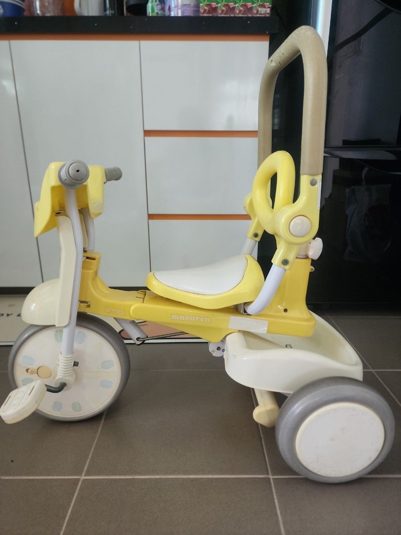 Iimo Foldable Tricycle (Category: Other Babies Going Out Needs) located in Singapore. Submitted by ohoka78 (Listing ID 1373379128, Image 1). Description: Item in usable condition but with obvious wear and tear such as cracked rubber and stickers peeling. The steering handle bar for parents is not functioning well as the connecting part (see last 2 pic) between the front wheel and the steering handle can come off if turn too wide. Definitely not f