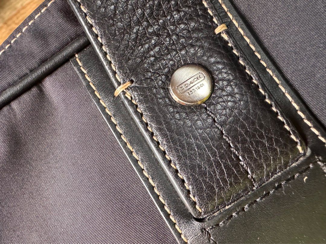 Coach Briefcase (Category: Briefcases) located in Lucban. Submitted by jakobv (Listing ID 1373430922, Image 3). Description: 9.8/10 This elegant briefcase is crafted from durable nylon with refined leather accents, combining functionality with a sleek, professional look. It shows very minimal signs of use and remains in pristine overall condition. Both the interior and exterior are exceptionally clean, with no major scuffs, stains, or marks. Idea