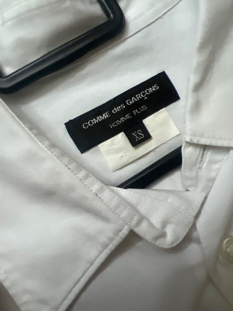 Comme des Garcons Homme Plus White Shirt XS (Category: Shirts) located in Singapore. Submitted by qpyqrx2nfq31052 (Listing ID 1373412839, Image 1). Description: Check out this Comme des Garcons Homme Plus white shirt! It's in great condition, as you can see from the video. The shirt is a classic white color and features a button-down design. It's a size XS, so it's perfect for those who prefer a more fitted look. The shirt is made of high-quality