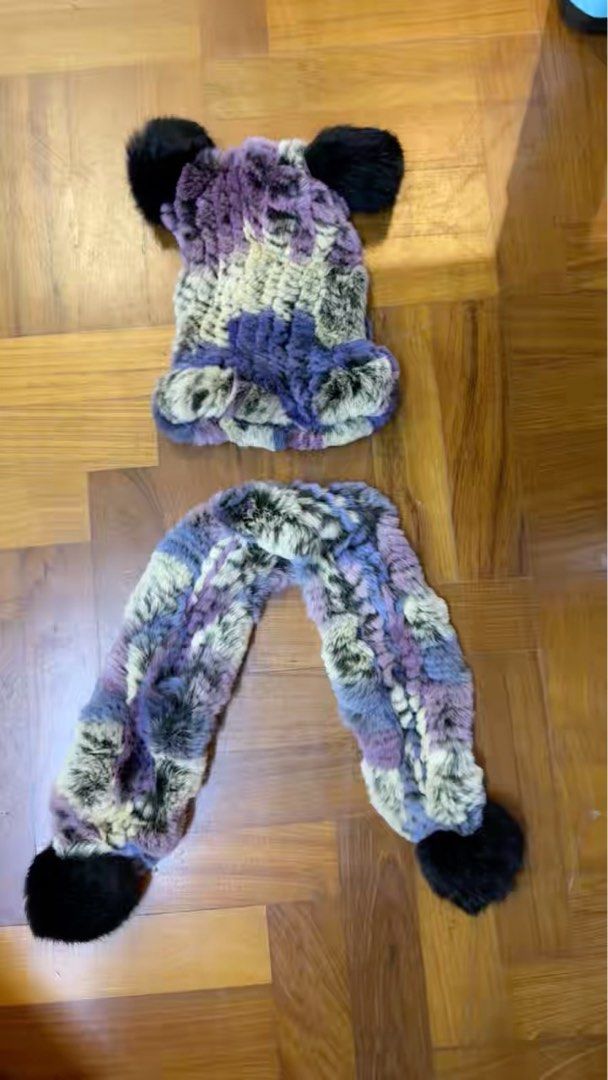 Rabbit Fur Hat and Scarf Set with Black Pom Poms (Category: Babies & Kids Fashion) located in Singapore. Submitted by vivashopaholic (Listing ID 1373526091, Image 1). Description: This is a super cute hat and scarf set! It looks like it's made of rabbit fur, with a mix of purple, cream, and black colors. The hat has two black pom poms on top, and the scarf has two at the ends. It looks really soft and cozy, perfect for keeping warm in style..