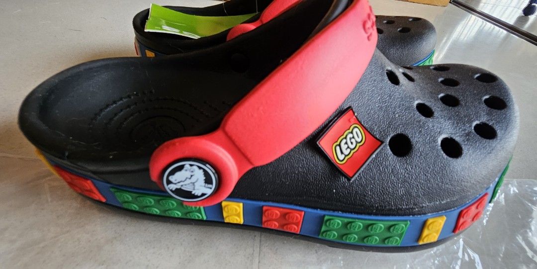 Crocs LEGO Classic Clogs - Brand New (Category: Babies & Kids Fashion) located in Singapore. Submitted by colorfulcloud (Listing ID 1378007458, Image 2). Description: - Brand new Crocs Classic Clogs - LEGO collaboration - Kids size. Crocs US size J1. Suitable for around 20 cm long foot. Depending on your kid's feet size, likely suitable for 7 to 8 years old. - Black base - Red straps - Colorful LEGO brick detailing - Includes original tags and pa