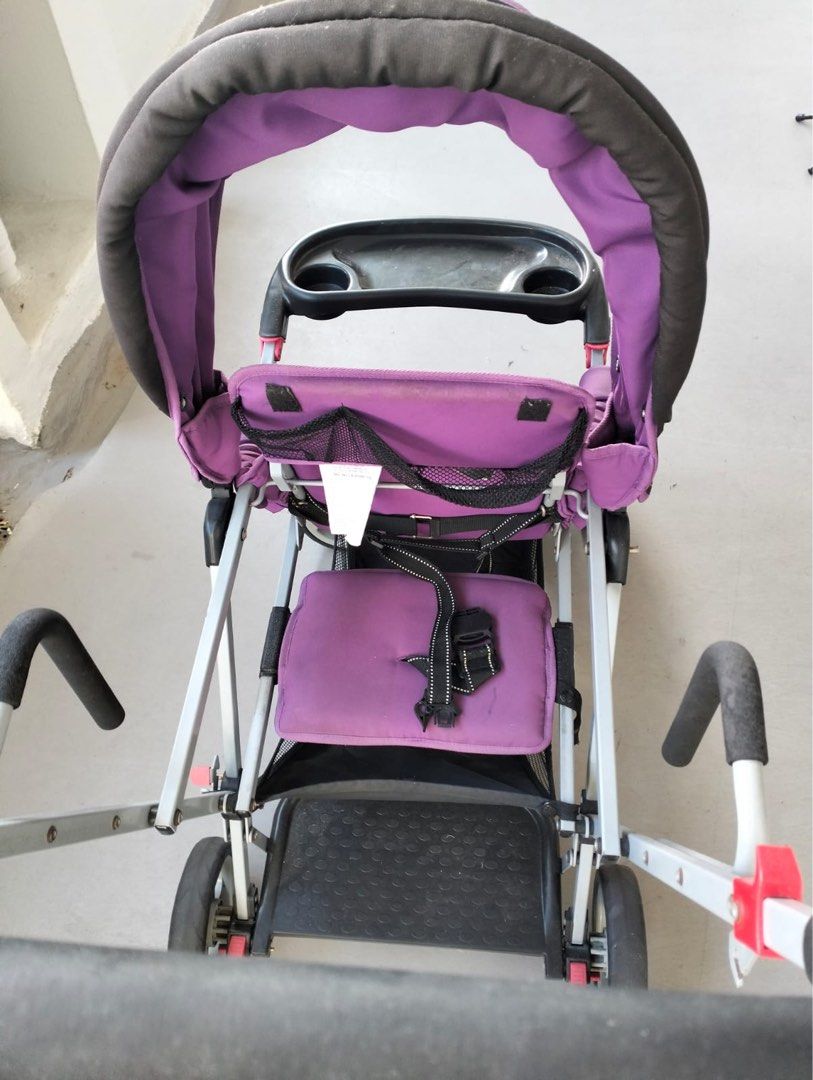 Joovy Caboose Ultralight Stroller - Purple (Category: Strollers) located in Singapore. Submitted by q8jxcskyhy05248 (Listing ID 1378026205, Image 3). Description: Used Joovy Caboose Ultralight stroller. Features a purple seat and canopy. Includes a tray with cup holders. Shows signs of use, but still functional. Great for parents with multiple children. Folds for easy storage..