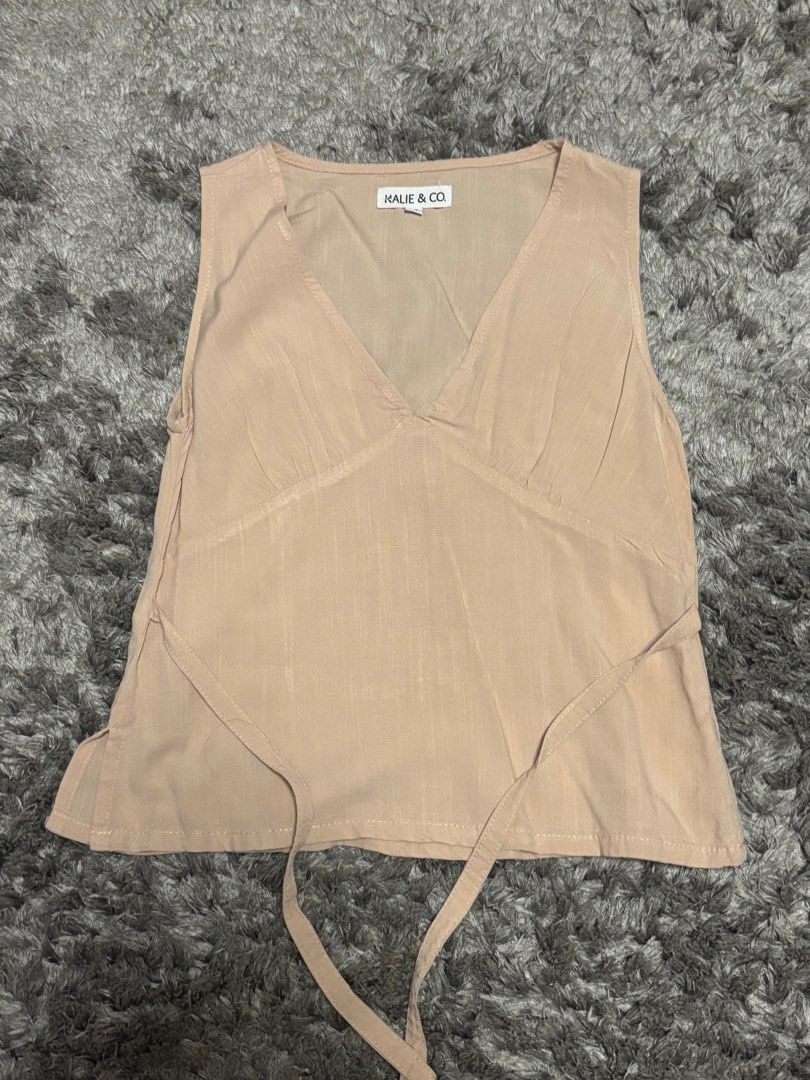 Tie top v-neck from Kalie & Co. (Category: Sleeveless) located in Manila. Submitted by pauly2112 (Listing ID 1378062555, Image 1). Description: Beige tie/ribbon top from local ph brand Kalie & Co. Unused, originally sold for 1495php rfs: doesn’t fit/decluttering flaws: none m.o.p.: Gcash delivery: Lalamove (buyer will shoulder sf).