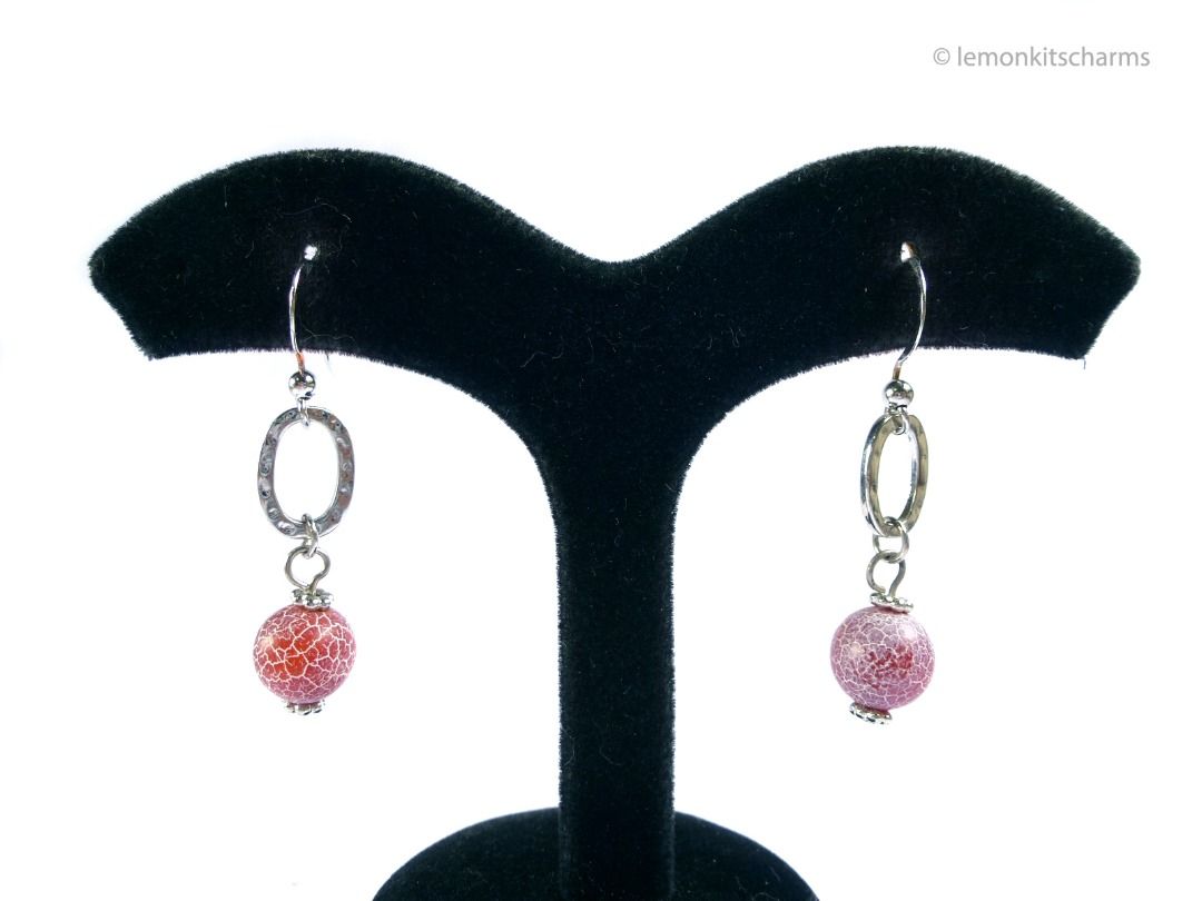 Vintage 1990s Red Crackled Glass Dangling Earrings, er2667-ci (Category: Earrings) located in Singapore. Submitted by lemonkitscharms (Listing ID 1378138153, Image 2). Description: Vintage 1990s - Y2K Red Crackled Glass Dangle Earrings, for pierced ears. Good condition, slight copper base showing on one of the hooks and the loops from wear. Silvertone with oval hammered metal ring, and what looks to be a glass bead with a white crackled effect. P