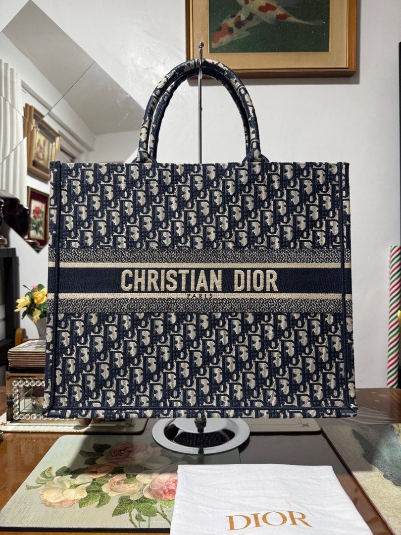 CHRISTIAN DIOR BOOKTOTE OBLIQUE LARGE (Category: Luxury Bags & Wallets) located in Cavite. Submitted by carrycouturebymsu (Listing ID 1379909641, Image 1). Description: • Outer canvas 100% • Color navy blue with two top handles and main compartment • Logo embroidery • 🇯🇵 Self Authentication is advised • Coded/ Made in Italy • Actual pic posted • What you see is what you get Dimensions: 42 x 35 x 18.5 cm Inclusions : Dustbag, card ~ To all buyer