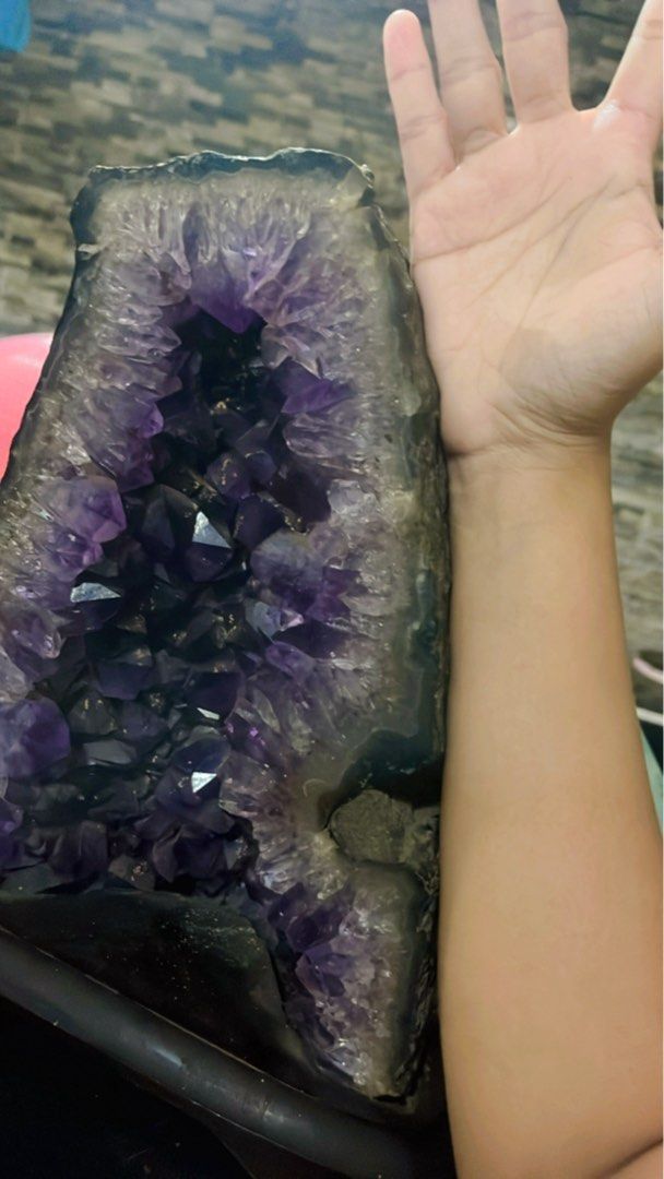 Geode kristal amethyst alami (Kategori: Pajangan Antik) berada di Parung. Dikirim oleh mayakeumal90436 (ID iklan 1379899404, Gambar 1). Deskripsi: Detail Produk Pajangan Amethyst Geode • Jenis: Geode kristal amethyst alami • Warna: Ungu tua ke ungu muda dengan kilau kristal alami • Bentuk: Potongan terbuka berbentuk setengah silinder vertikal • Ukuran: Perkiraan tinggi sekitar 20–23 cm (dilihat dari perbandingan dengan lengan tangan) • Berat: Kem