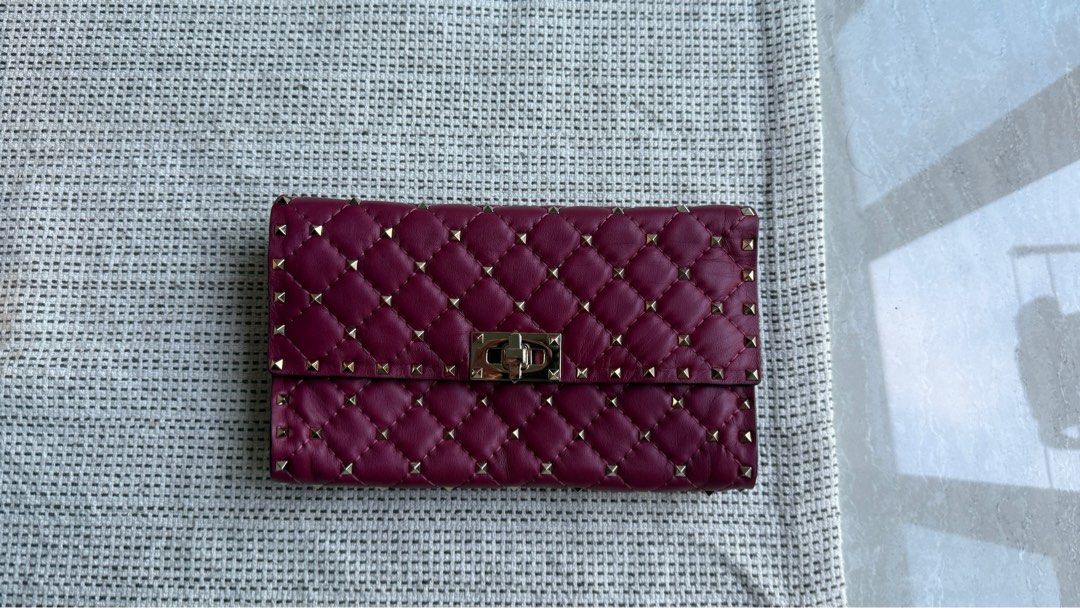 Valentino Garavani Rockstud Quilted Wallet (Category: Bags & Wallets) located in Singapore. Submitted by il_____ (Listing ID 1379930968, Image 1). Description: Beautiful Valentino Garavani Rockstud wallet in excellent condition. Features a quilted design with signature Rockstud embellishments. The wallet has a secure clasp closure. A stylish and practical accessory..