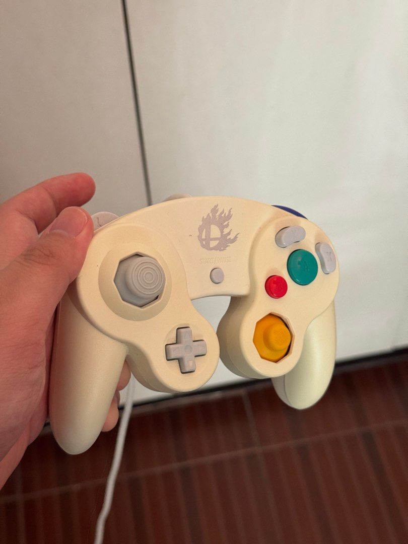 Japan-Exclusive White GameCube Controller (Smash 4) (Category: Controllers) located in Quezon City. Submitted by cks_gaming (Listing ID 1380180468, Image 2). Description: Selling an authentic Japan-exclusive GameCube controller: 1x Smash 4 Edition White (Japan Exclusive) – PHP 2,500 – with Smash logo, rare, good condition, slight yellowing (normal for age), all buttons and sticks responsive. Perfect for Smash, retro gaming, or collectors looking 