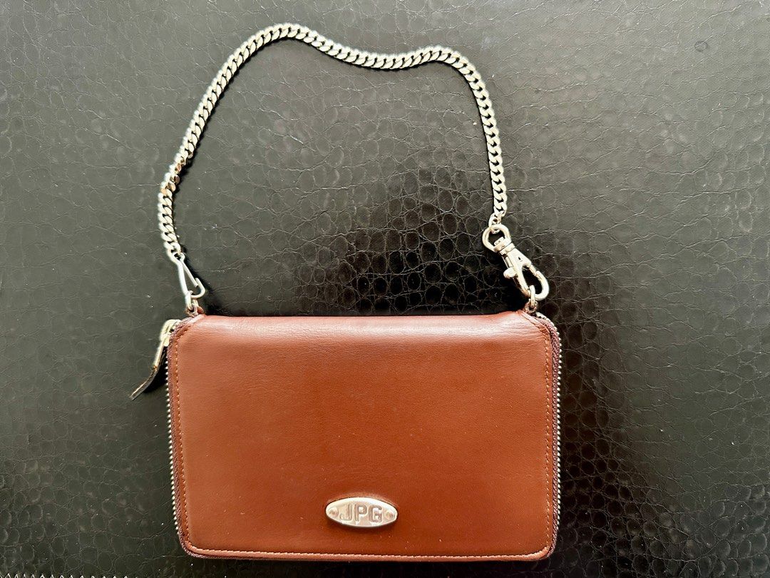 JPG Leather Wallet with Chain (Category: Purses & Pouches) located in Singapore. Submitted by refreshlife (Listing ID 1380335922, Image 1). Description: - Brown leather wallet with a silver chain - can be used as a simple bag - Silver chain can be detached to be used as a regular wallet. - Zip all around closure - Features multiple card slots and compartments. - The wallet has a zip closure and a small coin pocket. - The JPG logo is visible on th