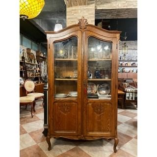 由 19th.antique (刊登 ID 1380592270，圖片 1) 提交，位於 台北市 (Taipei) 的 【🇫🇷 法國・手工雕刻橡木雙開門收藏櫃・鄉村古典風】 #223144 (類別：書櫃、櫃子)，說明：【🇫🇷 法國・手工雕刻橡木雙開門收藏櫃・鄉村古典風】 這件來自法國的古董雙門展示收藏櫃，展現20世紀初期鄉村古典風格的典雅氣質。 櫃體採用天然紋理極美的橡木實木手工打造，木紋細緻清晰，色澤溫潤迷人，搭配玻璃雙開門設計，兼具實用與展示功能。上緣拱形線條搭配中央葉飾雕刻，優雅柔和地呼應整體曲線比例，下緣則承襲洛可可風格的弧形雕花與細腿設計，散發法式古典家具的雅致氣息。 櫃門下半部雕飾紋樣細緻立體，典雅不浮誇，搭配原裝古銅鎖飾與原始鑰匙（可正常上鎖），細節處皆體現職人手工雕刻的功力。內部五層收納空間層距適中，非常適合陳列瓷器、銀器、藏書或工藝收藏，亦可靈活運用為藝廊或選物店展示主體。 🔸 製作時期：約1900年代初期 🔸 尺寸：約 寬105 × 深40 × 高188 