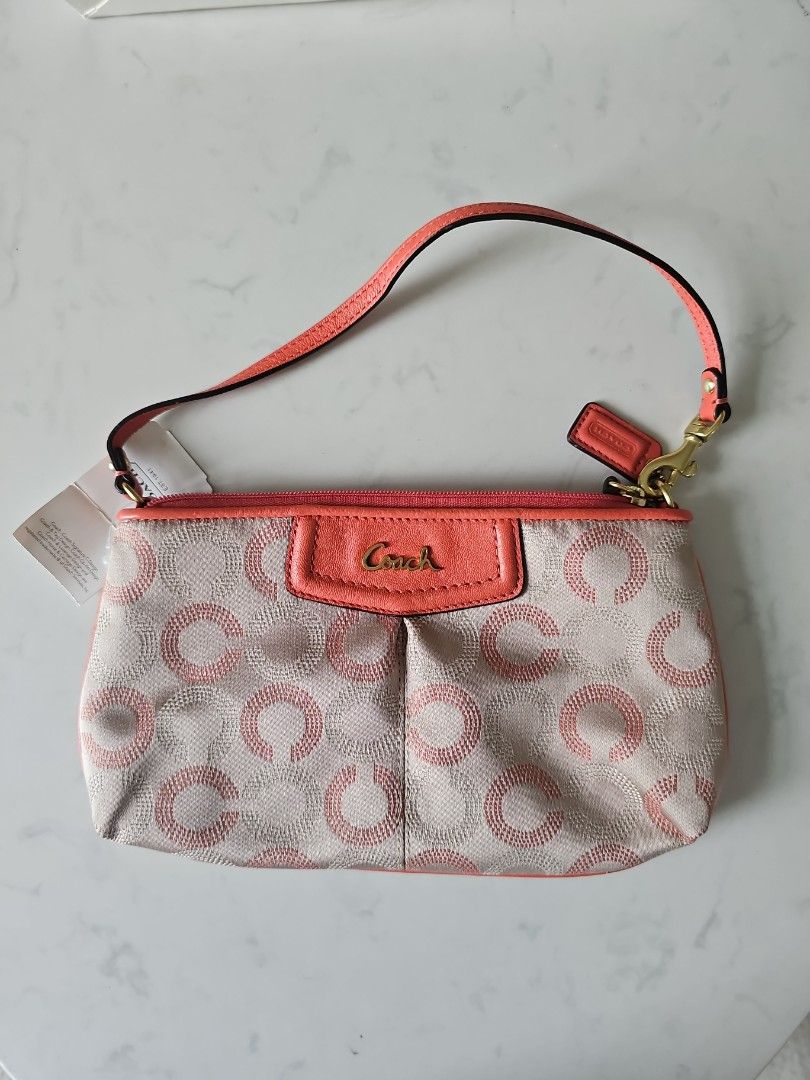 Coach Ash Dot Op Art Wristlet (Category: Bags & Wallets) located in Singapore. Submitted by Lemon_Chamomile (Listing ID 1380607913, Image 1). Description: - Brand new Coach wristlet - Ash Dot Op Art design - Comes with original box and tags - Features coral-colored wrist strap and accents - Received as farewell gift, never use before - Ideal for carrying essentials stylishly - Inner compartment has 8 cards slot - Length from top is Abt 21 cm.