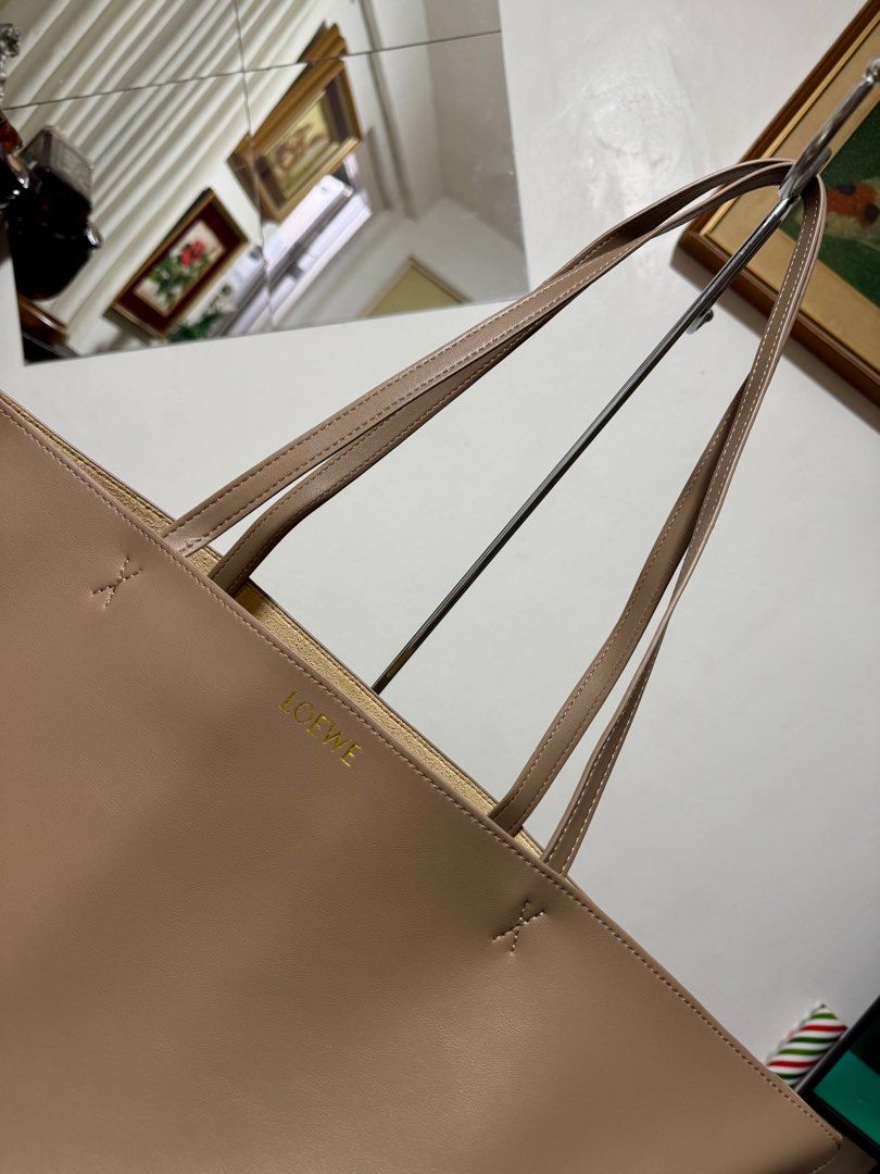 LOEWE XL Puzzle Fold Tote Bag (Category: Luxury Bags & Wallets) located in Cavite. Submitted by carrycouturebymsu (Listing ID 1380690637, Image 3). Description: • Calf leather 100% • Folded design in tan/taupe with two flat shoulder straps, logo stamp to the front, smooth grain, no fastening, suede lining and main compartment. • No additional photos • 🇯🇵 Self Authentication is advised • Coded/ Made in Spain • Actual pic posted • What you see is