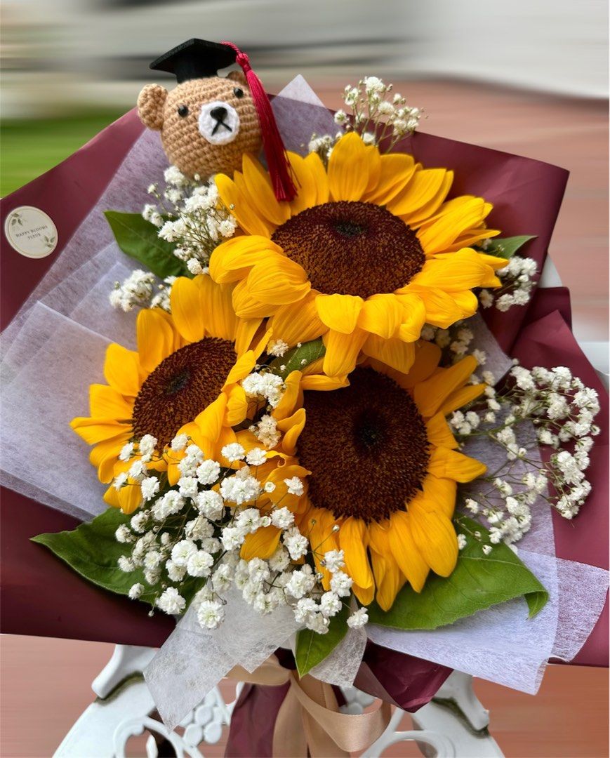 Sunflower Graduation Bouquet with Teddy Bear, Graduation Bouquet, Fresh Flowers Bouquet (Category: Flowers & Bouquets) located in Singapore. Submitted by alimomma (Listing ID 1380671681, Image 2). Description: Beautiful sunflower bouquet, perfect for graduation! Includes three vibrant sunflowers, baby's breath, and a cute graduation teddy bear. Wrapped in elegant burgundy paper with a ribbon. A thoughtful and cheerful gift. * Wrapper colours can 