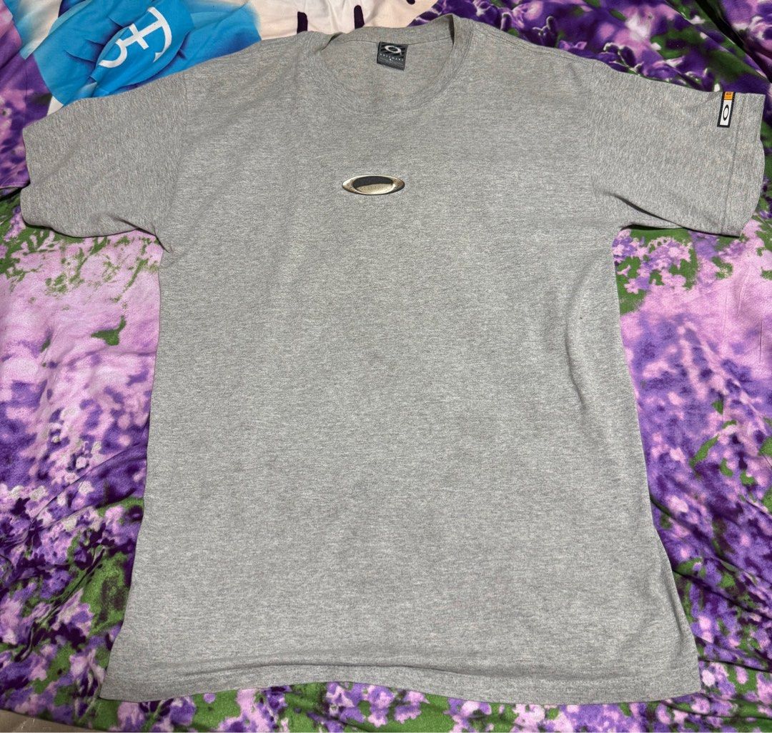 Oakley Logo Grey T-Shirt - Size L (Category: Tshirts & Polo Shirts) located in Singapore. Submitted by riquespore38118 (Listing ID 1380877701, Image 1). Description: Classic grey Oakley t-shirt. Features the Oakley logo on the chest and sleeve. Size L. Made from a comfortable material, perfect for everyday wear. In good condition, with no major flaws. Able to negotiate.