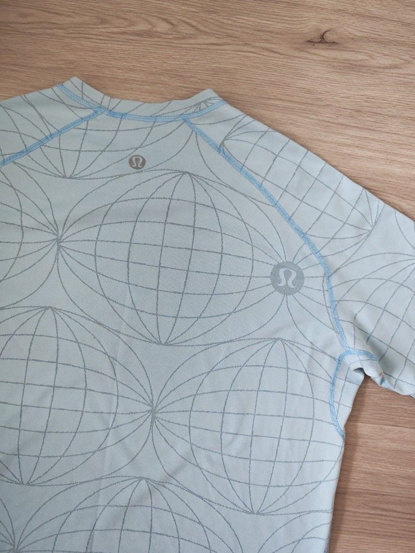 Lululemon Blue Geometric Print Short Sleeve Shirt (Category: Activewear) located in Singapore. Submitted by lulululalalala (Listing ID 1380942153, Image 3). Description: Check out this Lululemon short sleeve shirt! It's a light blue color with a cool geometric print. The shirt is size L. It has a small logo on the front and the stitching looks good. It's been lightly used, so it's in great shape. It's perfect for workouts or casual wear. If you'r