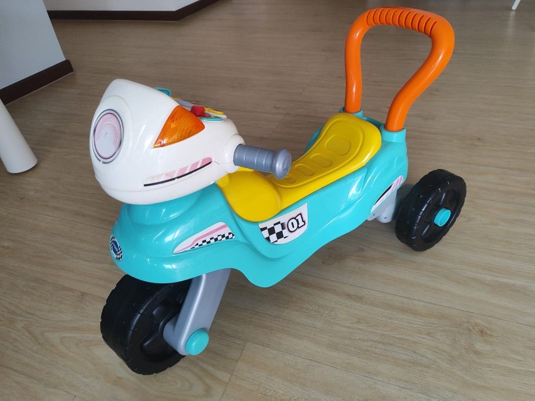 Kids' Ride-On Motorcycle Toy (Category: Toys & Games) located in Singapore. Submitted by nicesharebuy (Listing ID 1381141180, Image 1). Description: - Fun, colorful ride-on motorcycle for toddlers. - Interactive buttons and lights on the dashboard. - Sturdy 3-wheel design for stability. - Suitable for indoor and outdoor play. - Measurements available in photos..