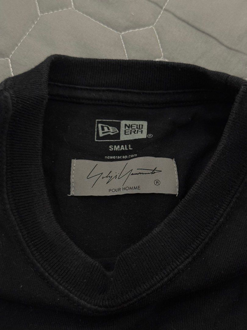 New Era x Yohji Yamamoto Black T-Shirt (Category: Tshirts & Polo Shirts) located in Singapore. Submitted by canshsm (Listing ID 1381270495, Image 2). Description: Authentic New Era x Yohji Yamamoto black t-shirt. Features a small New Era logo on the sleeve and a Yohji Yamamoto signature print on the back. Made from 100% cotton. Size is YL..