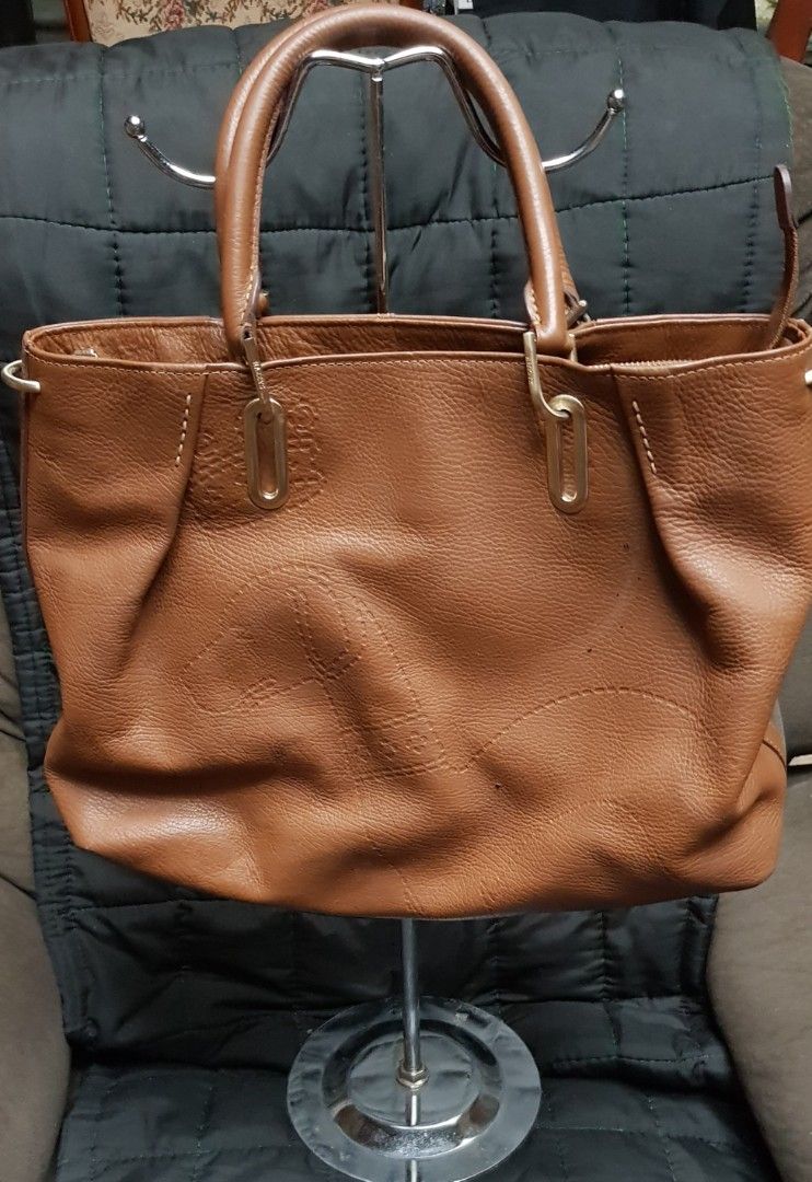 Tan-brown Hazzys hand-tote bag (Category: Tote Bags) located in Quezon City. Submitted by practibagsplusmnl (Listing ID 1381193917, Image 1). Description: Tan-brown Hazzys hand-tote bag, thick, but smooth, soft leather; structured bag..