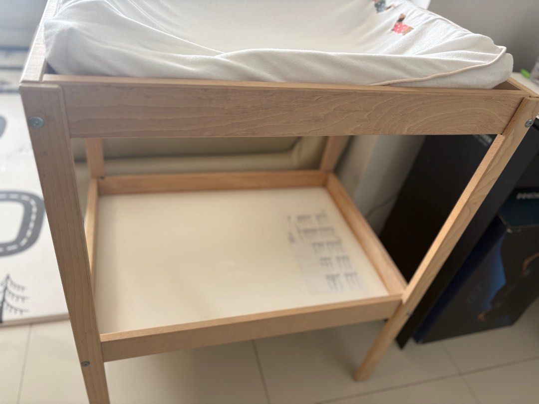 IKEA Changing Table (Category: Changing Tables & Stations) located in Singapore. Submitted by divinelife (Listing ID 1381462839, Image 3). Description: Includes the changing pad (some parts a bit deflated and comes with the cover). Features a shelf for storage. Solid wood frame. Clean and ready for use. Perfect for a nursery or baby's room. Use for 1year only baby has grown. Self-collected. .