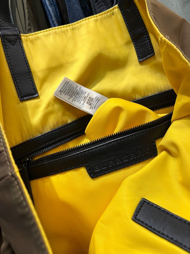 Burberry Nylon Leather Handle Tote Bag (Category: Luxury Bags & Wallets) located in Quezon City. Submitted by forgarments (Listing ID 1381493822, Image 3). Description: Burberry Nylon Leather Handle Tote Bag Excellent Condition - Need a Light Cleaning Width: 19 Inches Height: 18 Inches Depth: 4 Inches Top handle: 10 inches Crafted from durable nylon inside and out, this tote features a two-tone design with luxurious leather handles. The interior 