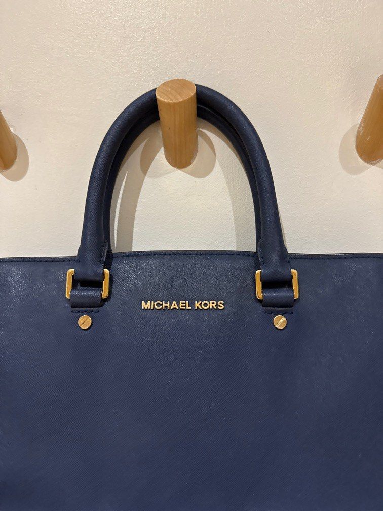 Michael Kors Structured Navy Handbag (Category: Luxury Bags & Wallets) located in Quezon City. Submitted by kimyscloset (Listing ID 1381643243, Image 2). Description: Michael Kors Structured Navy Handbag ✨ Authentic Michael Kors 🎒 Spacious, structured design – fits laptop, docs, and more 💙 Elegant navy with gold hardware 👜 With top handles + adjustable shoulder strap 📍 In good condition 💸 Selling for ₱2,500 Perfect for work or everyday sophi