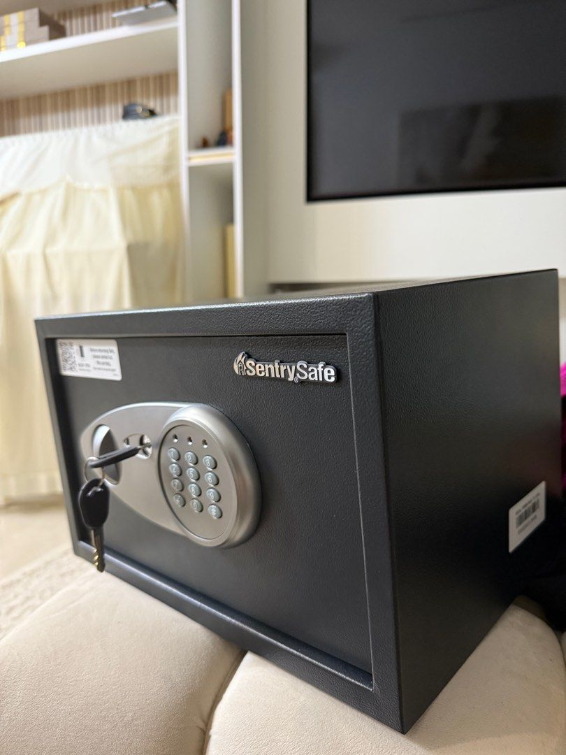 SentrySafe Electronic Safe with Key (Category: Safe) located in Singapore. Submitted by mugened (Listing ID 1378279513, Image 1). Description: This SentrySafe electronic safe is in excellent condition. It comes with a key and a digital keypad for easy access. Perfect for securing valuables at home or in the office. The safe is sturdy and reliable. 35cm x 25cm x 22cm.