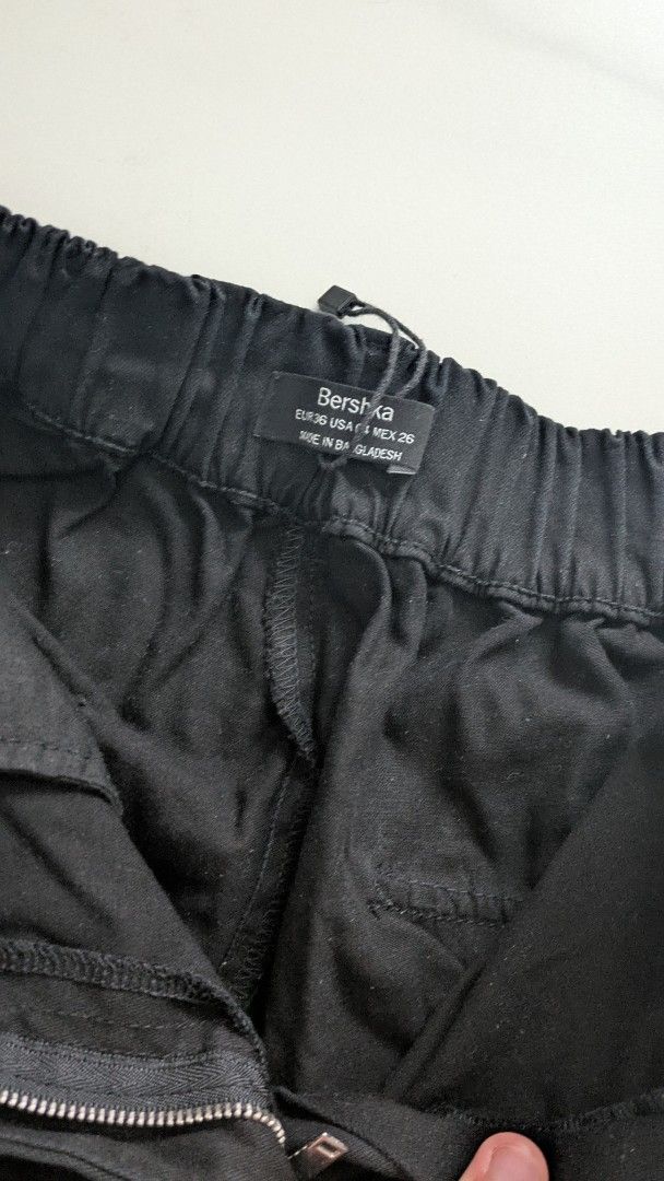 Bershka Black Cargo Pants with Pockets (Category: Other Bottoms) located in Singapore. Submitted by jinjamss (Listing ID 1377685833, Image 2). Description: Bershka black cargo pants with multiple pockets and comfortable elastic waistband with adjustable drawstring cords at the ankles. Item fits me baggy in real life than pictures when I loosen the ankle cords..