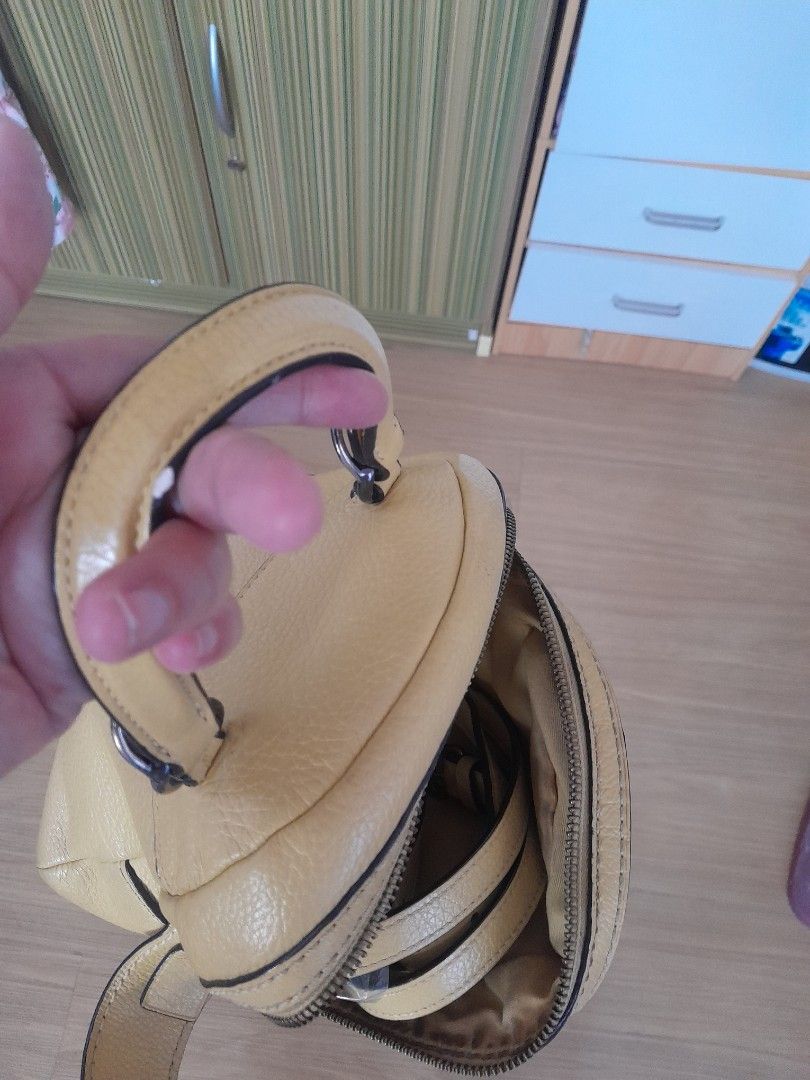 Coach small backpack (Category: Backpacks) located in Angeles City. Submitted by declutterhub (Listing ID 1381728450, Image 3). Description: original yellow small coach bag. can be backpack and sling. with signs of usage sa creed and handle rfs: too many bags.