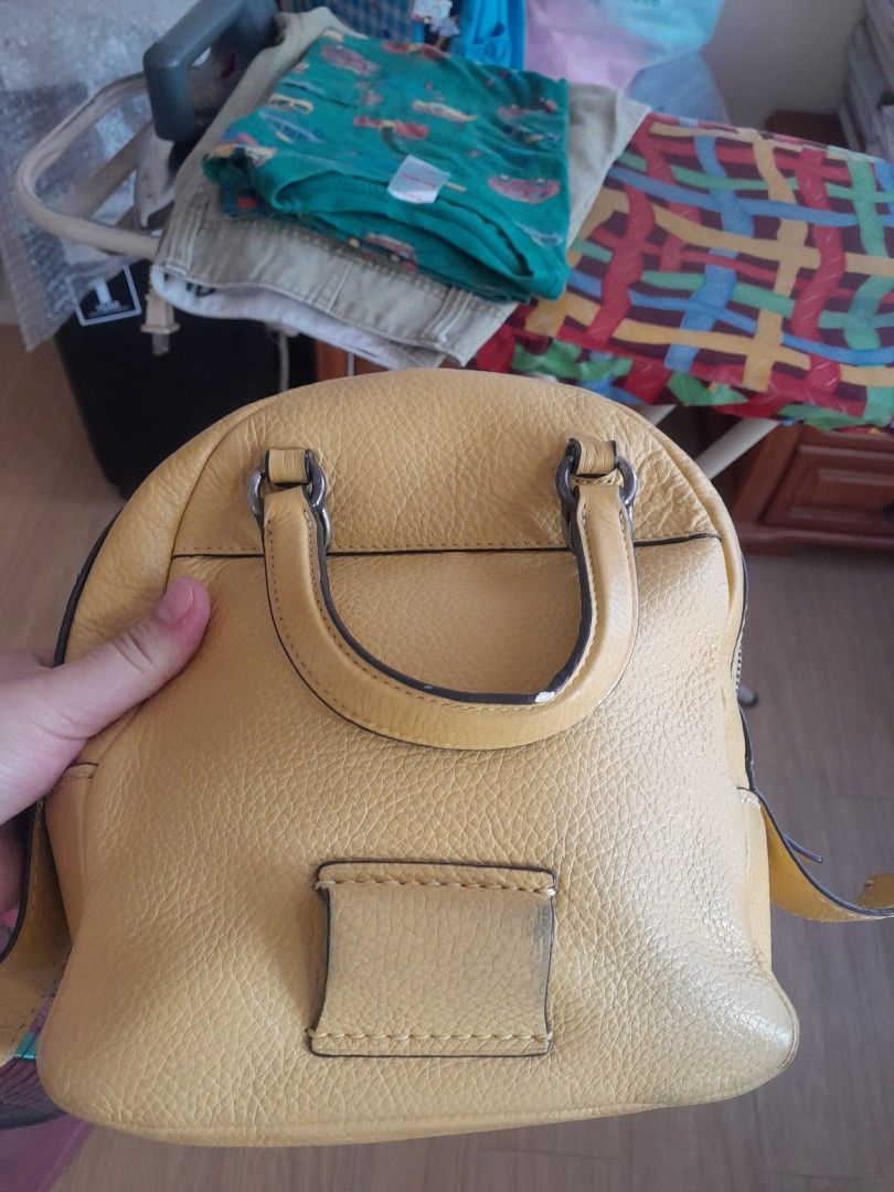 Coach small backpack (Category: Backpacks) located in Angeles City. Submitted by declutterhub (Listing ID 1381728450, Image 2). Description: original yellow small coach bag. can be backpack and sling. with signs of usage sa creed and handle rfs: too many bags.