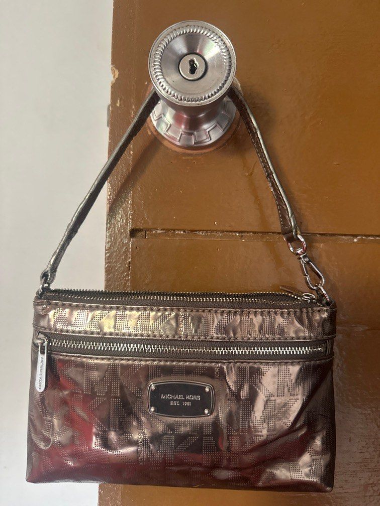 Michael kors pochette bag (Category: Luxury Bags & Wallets) located in Imus. Submitted by bunny_mei (Listing ID 1382337104, Image 1). Description: Mk monogram pochette bag Has a slight cracks in the handle and a red stain in the back (barely noticeable) .