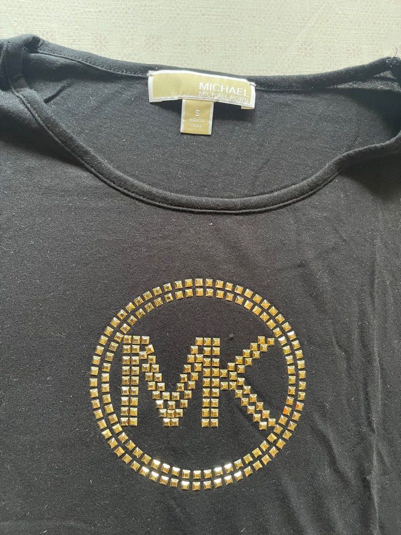Authentic Michael Kors T-shirt (Category: Shirts) located in Quezon City. Submitted by RoxyB (Listing ID 1383312083, Image 3). Description: Preloved MK black t-shirt. Fits S-M. In very good condition. Used twice only. RFS: Decluttering .