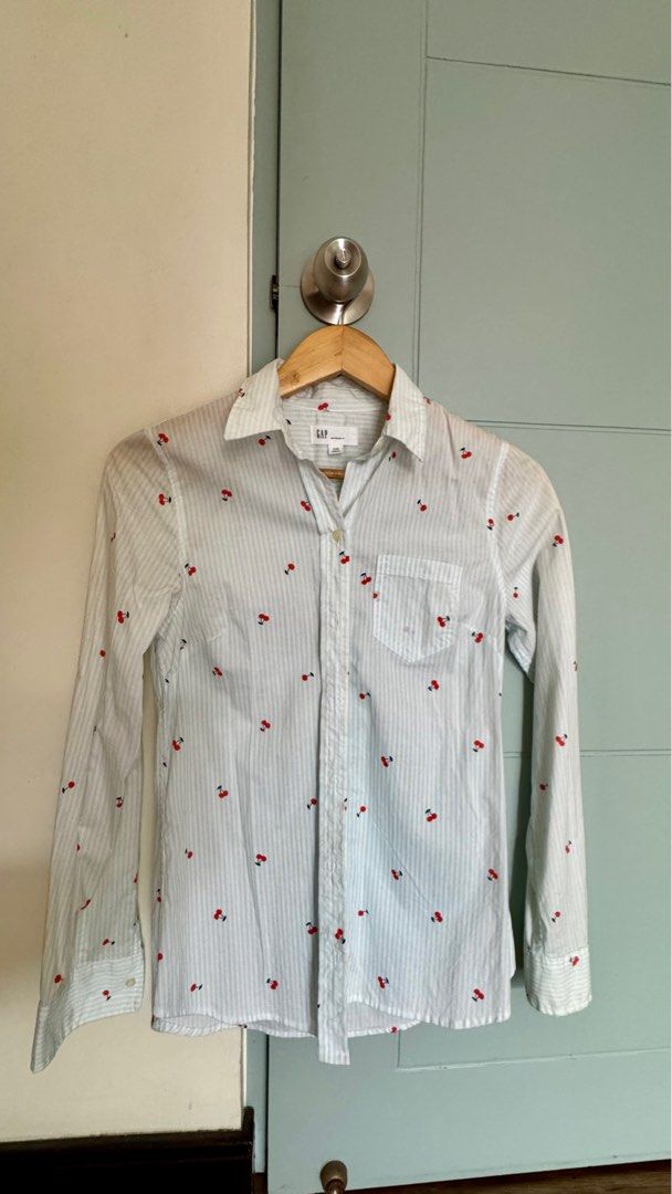 Button Down Shirt Longsleeves (Category: Longsleeves) located in Quezon City. Submitted by 2ndtake (Listing ID 1383297231, Image 1). Description: Gap Women’s Button Down Shirt with light blue and white striped pattern and has small red cherry motifs. The shirt is long-sleeved with button cuffs and a classic collar. Lightweight, breathable fabric, cotton, suitable for layering or wearing on its own. The front features a button closure, and it has 