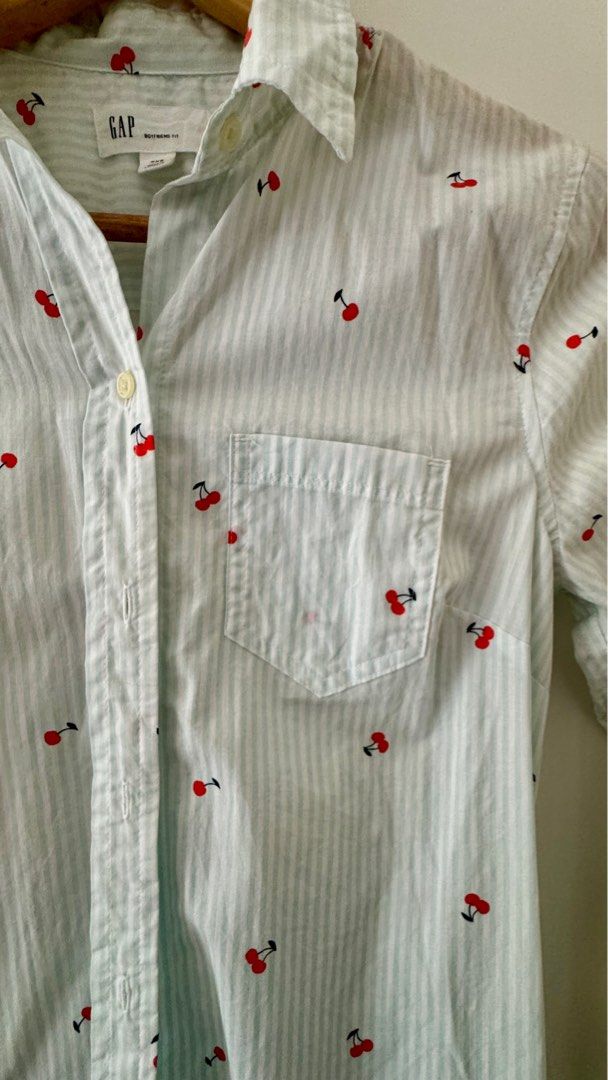 Button Down Shirt Longsleeves (Category: Longsleeves) located in Quezon City. Submitted by 2ndtake (Listing ID 1383297231, Image 2). Description: Gap Women’s Button Down Shirt with light blue and white striped pattern and has small red cherry motifs. The shirt is long-sleeved with button cuffs and a classic collar. Lightweight, breathable fabric, cotton, suitable for layering or wearing on its own. The front features a button closure, and it has 