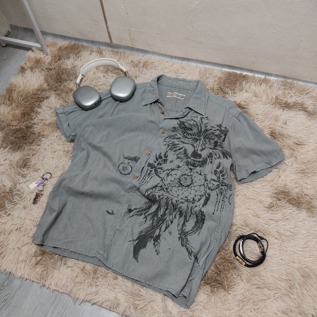 Y2K Dreamcatcher Wolf Print Button-Up Shirt (Category: Tshirts & Polo Shirts ) located in Antipolo. Submitted by newvins (Listing ID 1383617181, Image 3). Description: Width: 20 Length: 27 Size: medium Color: Gray Color rate: 9.6/10 Issue: none Condition: VeryGood Condition.