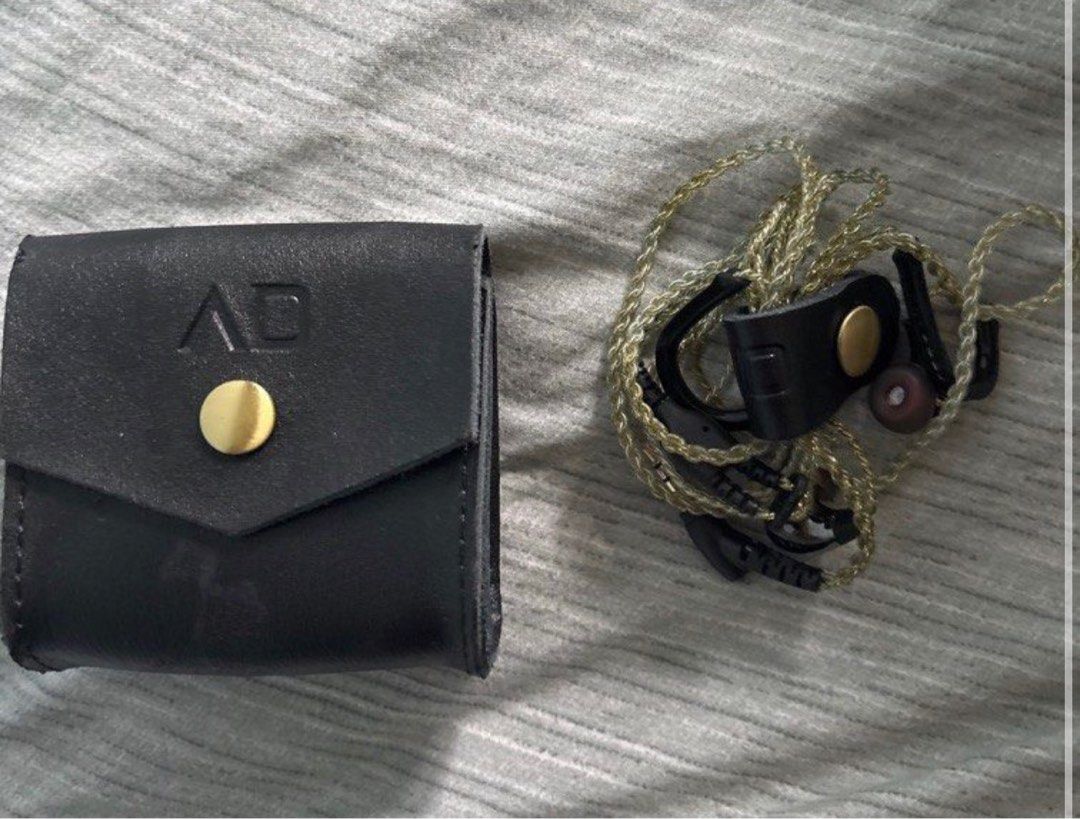 Alpha and delta iem In-Ear Earphones with Case (Category: Earphones) located in Singapore. Submitted by kazelaze (Listing ID 1378388439, Image 1). Description: In-ear earphones with a braided cable and a leather case. The case has a gold button closure and the initials 'AD' embossed on it. The earphones appear to be in good condition. .