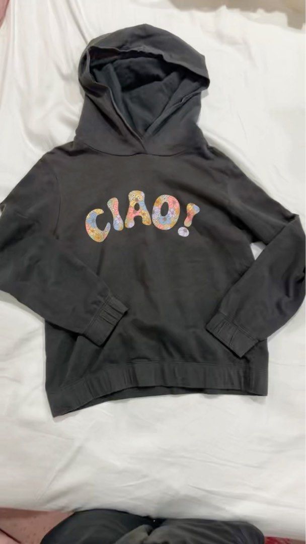 Ciao! Graphic Hoodie (Category: Babies & Kids Fashion) located in Singapore. Submitted by blissfully28 (Listing ID 1378505371, Image 1). Description: This is a dark grey hoodie with the word "Ciao!" in a colorful, floral-like font. It has a hood and it's in good condition. It's a casual and comfortable piece, perfect for everyday wear. The design is fun and eye-catching, making it a great addition to any wardrobe. It's a versatile item that can b