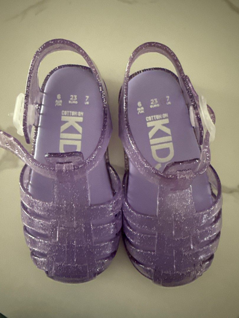 Cotton On Kids Jelly Sandals - Size 23 (Category: Babies & Kids Fashion) located in Singapore. Submitted by _honeywaffles (Listing ID 1378372734, Image 1). Description: Cotton On Kids jelly sandals, size 23. Sparkly purple, excellent condition, barely worn. Secure strap..